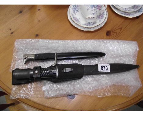 A German bayonet in leather sheath marked 'Coppel M BGH' and a small German dagger with eagle head handle, sheathed.