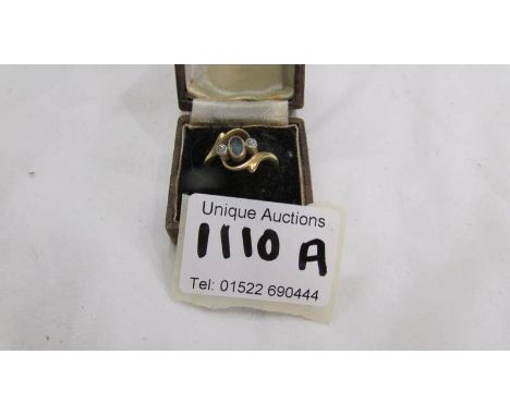 A gold ring (hall mark indistinct but possibly 18ct) set central blue stone and 2 small diamonds, size M.