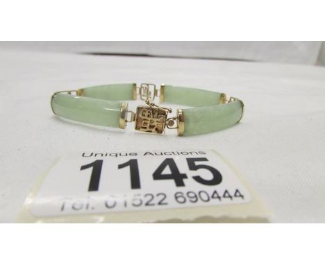 A gold Chinese bracelet with jade inserts stamped 9ct gold.