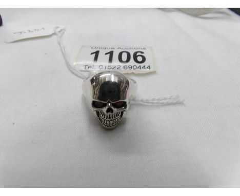 A silver skull ring with red eyes. Marked 925, size O.