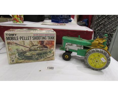 A boxed 'Tomy' battery operate plastic pellet shooting tanks and a battery operated plastic and tin plate tractor.