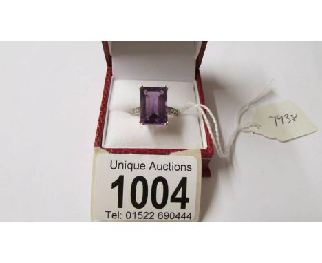 A 9ct gold ring set large emerald cut amethyst and with diamond set shoulders, (amethyst 10mm x 14mm), size N.