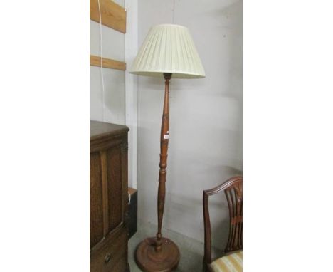 A carved standard lamp with shade.