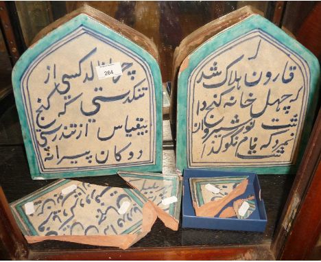 Two Persian Iznik blue and white calligraphy arched top tiles, 28cm x 21cm, together with shards of a similar tile