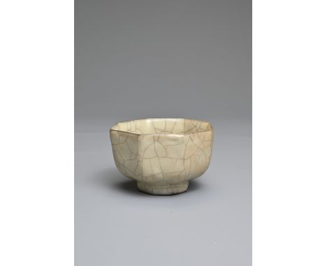 A CHINESE GUAN TYPE OCTAGONAL CUP. Well potted with eight faceted sides and foot covered in a beige tone glaze with network o