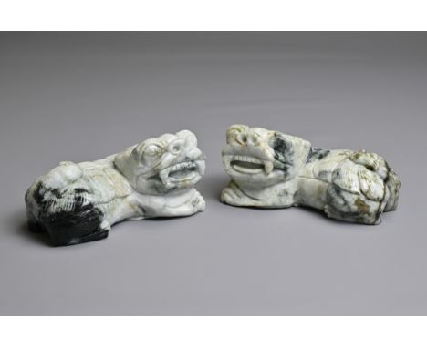 A PAIR OF CHINESE CARVED JADE LIONS, 20TH CENTURY. A mirrored pair recumbent on cash coins. 11.5cm length. Total weight 1394 