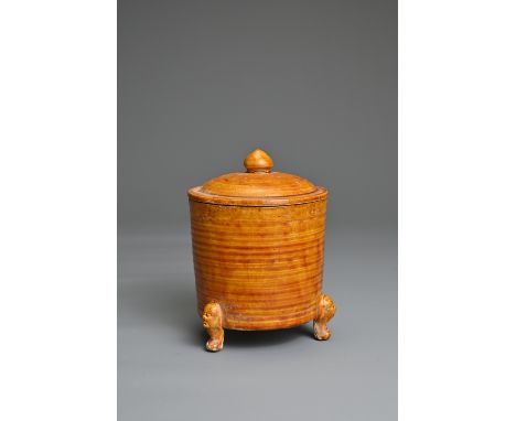 A CHINESE AMBER GLAZED POTTERY TRIPOD CENSER AND COVER. Of cylindrical form with ribbed body on three animal form feet. The e