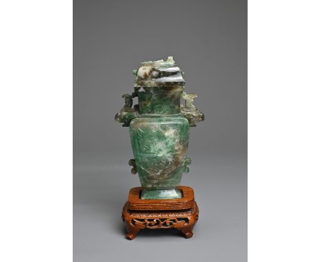 A CHINESE CARVED JADEITE VASE AND COVER. Dark green jade of flattened baluster form with animal form handles, carved in relie