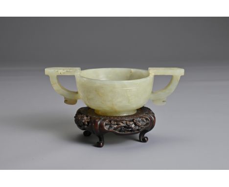 A CHINESE PALE CELADON JADE TWIN HANDLED CUP, LATE MING DYNASTY. Circular cup with Taotie mask handles to each side with a ba