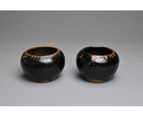 TWO CHINESE HENAN BLACK GLAZED POTTERY JARS. Of globular form on a short foot with slightly concave base. Covered in a black 