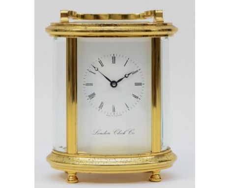 A 20th century English oval brass case carriage clock, the white enamelled dial with Roman numerals, bearing the retailer 'Lo