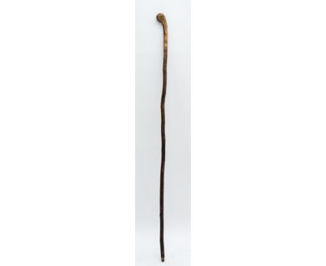 An Oriental walking stick of tapering form, the handle carved with the head of a Chinese Immortal, 92cm long. 