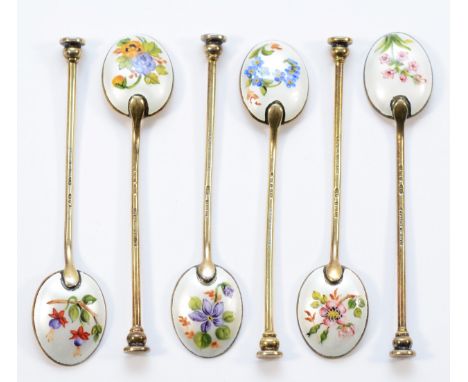 A silver gilt and enamel set of six coffee spoons, Birmingham  1957, the bowls decorated with different floral decoration on 