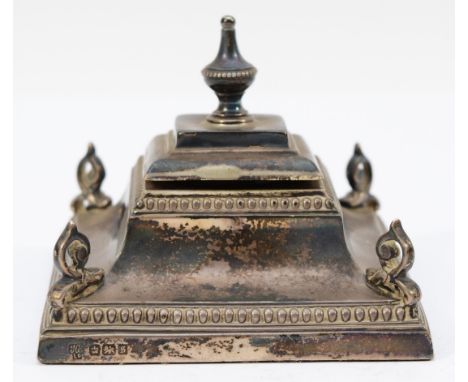 An Edwardian silver inkwell, Sheffield 1910, of square form, with bead border and scroll corners, 9 x 9cm, loaded. 