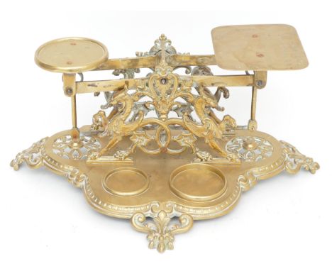 Set of late Victorian cast brass postal scales with ornate figural decoration on fleur-de-lis shaped supports, makers mark an