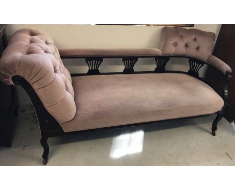 A late Victorian button backed chaise longue with dusky pink velvet upholstery. Carved detail to front, splayed design spindl