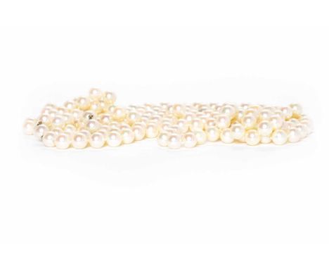 PEARL NECKLACEformed by spherical white pearls 8.7mm diameter, approximately 190cm long; along with two channel set baguette 