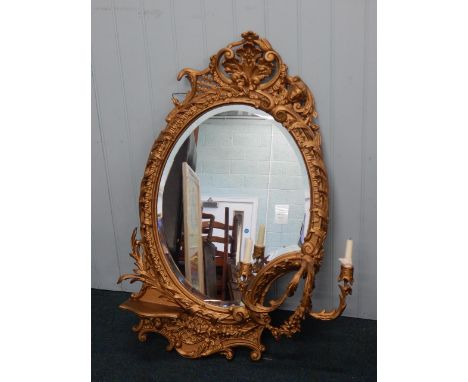 A late 19thC gilt gesso girandole, with a shaped bevelled plate, two candle arms and a shelf, 107cm high