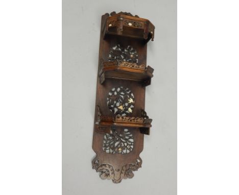 A Japanese hardwood three tier wall shelf, with applied decoration in Shiboyama style, with birds, flowers, etc, 103cm high, 