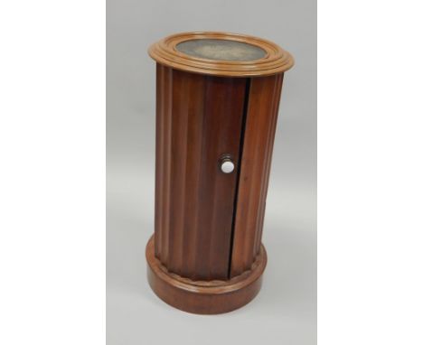 A Victorian pedestal pot cupboard, the top with a black canvas insert and a moulded edge above reeded sides and door, with ce