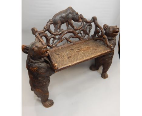 A late 19th-early 20thC Black Forest linden wood bench, carved with two bear shaped supports, the pierced back also carved wi