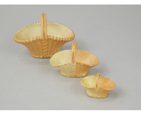 An associated set of three Royal Worcester blush ivory ground baskets, with moulded weave and gilded borders, printed marks i