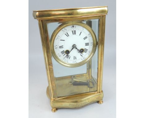 A late 19th/early 20thC French brass four glass mantel clock, with a white enamel dial, inscribed to the base "Presented by M