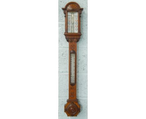 G.H. & C. Gowland Opticians, Sunderland.  A Victorian carved oak stick barometer, with thermometer etc. and gothic turned cis