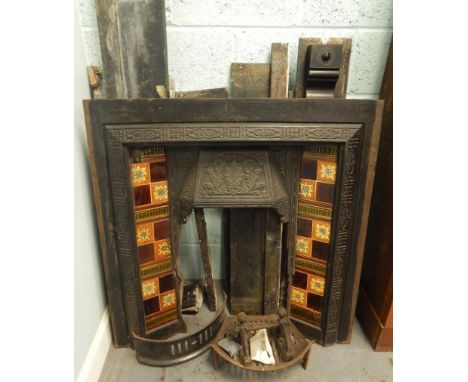 A Victorian black slate fireplace, the cast iron insert applied with ceramic tiles etc., (AF).