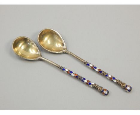 A pair of Russian white metal and champleve enamel spoons, each with gilt decoration and enamelled with flowers, leaves etc. 