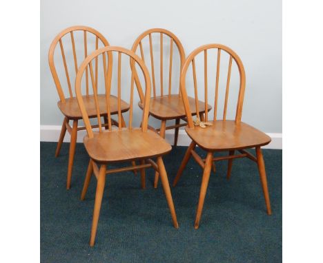 A set of four Ercol light coloured beech and elm stick back kitchen chairs, on turned legs.