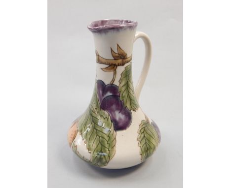 A Cobridge ceramic jug, decorated with plums and leaves, various marks to underside, copyright 1998, 19cm high
