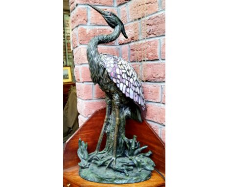 A large Tiffany style table lamp in the form of a heron, Verdigris effect base with amethyst coloured smoked glass wings/shad