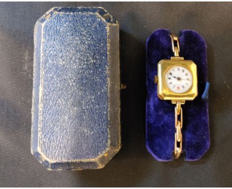An unsual late 19th/early 20th century 15ct gold lady's watch, the cantered square case with a circular white enamel dial bla