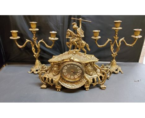 A 20th century gilt metal clock garniture, quartz clock, the case surmounted with a knight, three light two branch side cande