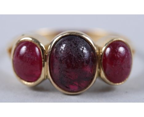 A yellow metal three stone ring set ruby cabochons, ring size R (wear to stones)