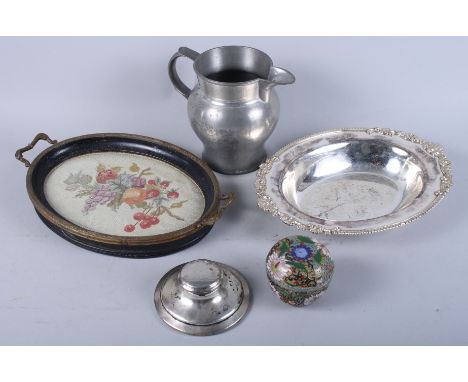 A silver inkwell, a pewter jug, a silver plated tray, a tray with inset needlepoint, and a small pot and cover