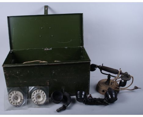 A quantity of telephone parts including rotary dials, fuses, wires, mouthpieces and other items, in a green toolbox