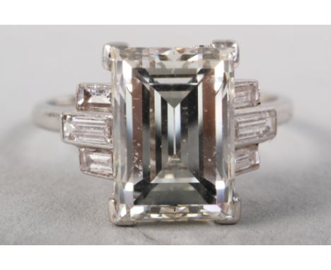 An Art Deco platinum ring set central emerald cut diamond, 3.52ct , with baguette cut diamonds to shoulders, ring size K/L, "