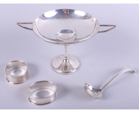 An early 20th century silver trophy cup, two silver napkin rings and a sauce ladle, 5.1oz troy approx