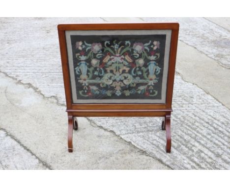 A 1920s walnut framed needlepoint fire screen, on splay supports, 24" wide, and a mahogany reeded column standard lamp, on tr