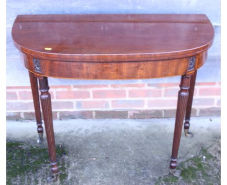 A George III mahogany bowfront fold-over card table, on reeded castored supports, 36" wide