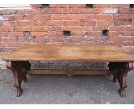 AN UNUSUAL 19TH CENTURY CARVED MAHOGANY DOUBLE SIDED BENCH, the plain two plank top supported by two heavily carved supports 