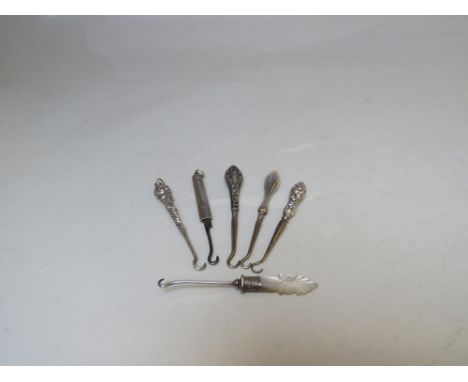 A COLLECTION OF SILVER MINIATURE BUTTON HOOKS, various makers and hallmarks, comprising silver handled, silver collared and h