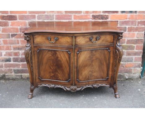 A REPRODUCTION MAHOGANY SERPENTINE FRONTED CABINET IN THE CHIPPENDALE STYLE, with carved detail to the front, supported on ho