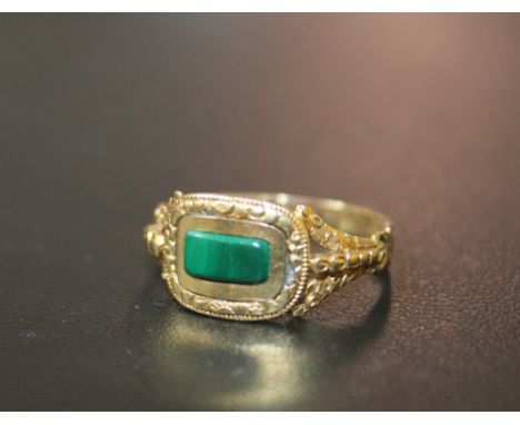 AN ANTIQUE GOLD MOURNING RING, inset with polished green stone and inscribed to the inside of the band with a date of 1878, a