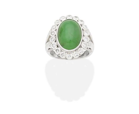 JADE AND DIAMOND RINGThe oval jadeite jade cabochon within a brilliant-cut diamond surround, between bifurcated similarly-cut