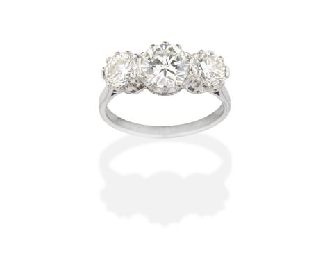 DIAMOND THREE-STONE RINGSet with a central brilliant-cut diamond, weighing 1.33 carats, between two similarly-cut diamonds, r