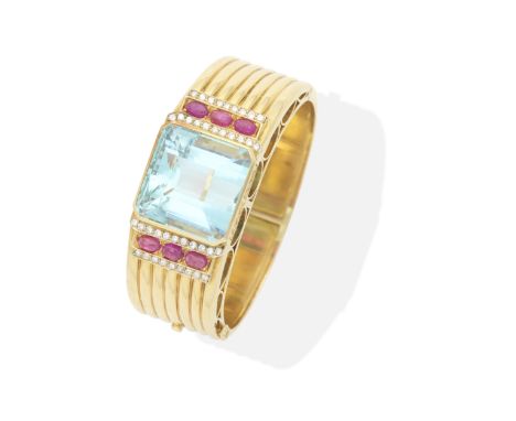 AQUAMARINE, RUBY AND DIAMOND BANGLEThe step-cut aquamarine between rows of brilliant-cut diamonds and oval ruby cabochons, th
