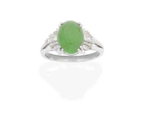 JADE AND DIAMOND RINGThe oval jadeite jade cabochon measuring approximately 10.7 x 8.1 x 3.9mm, between trifurcated tapered b